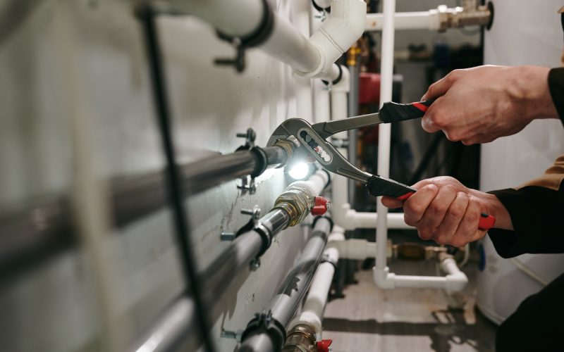 Hands of technician or plumber repairing broken pipes