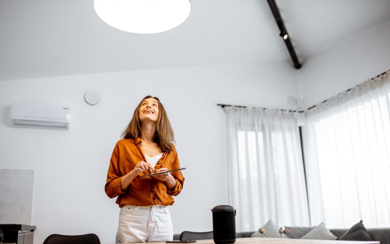 Woman controlling light with a smart home at home